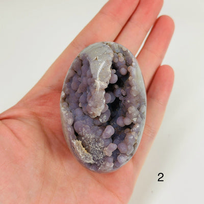 Hand holding up grape agate