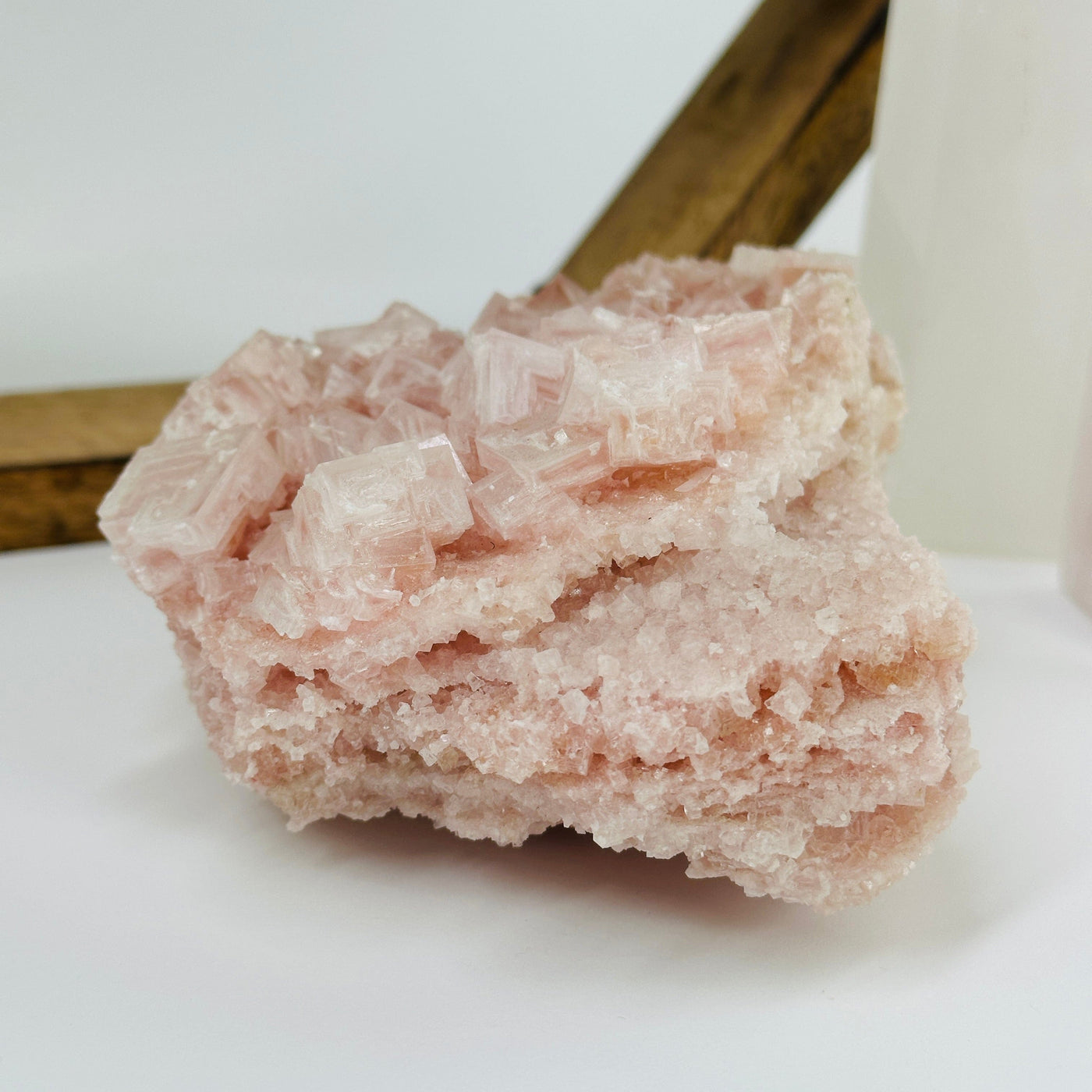 Pink halite cluster with decorations in the background