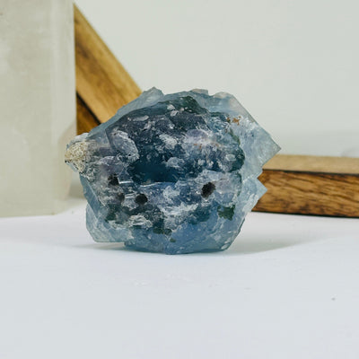 Blue fluorite crystal with decorations in the background