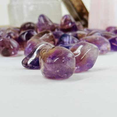 amethyst tumbled stones with decorations in the background