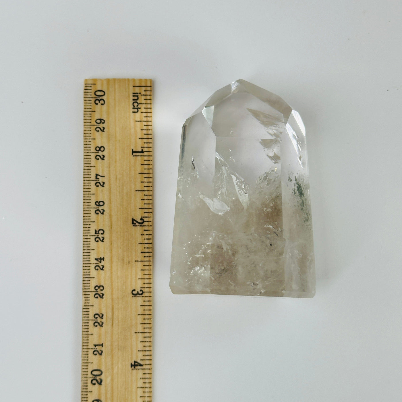 crystal quartz point next to a ruler for size reference