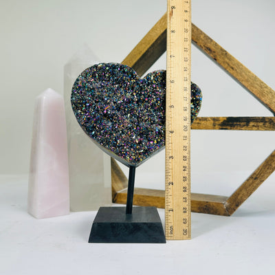 titanium coated heart on stand with decorations in the background