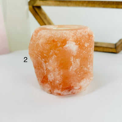 HIMALAYAN SALT CANDLE HOLDER WITH DECORATIONS IN THE BACKGROUND