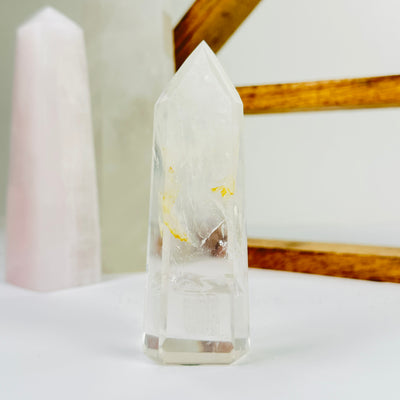 crystal quartz point with decorations in the background