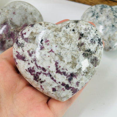 pink tourmaline heart with decorations in the background