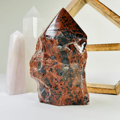 mahogany obsidian point with decorations in the background