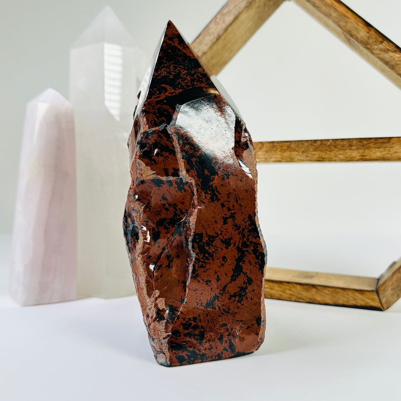 mahogany obsidian point with decorations in the background