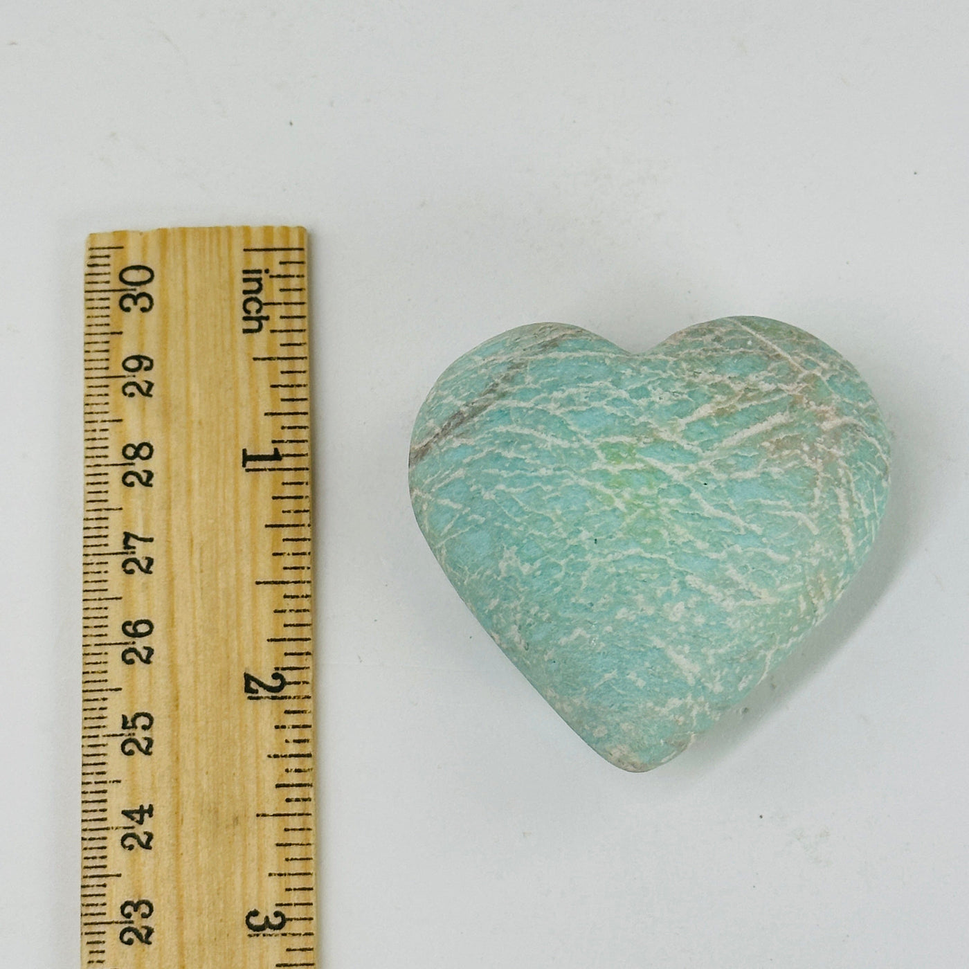 blue aragonite heart with decorations in the background