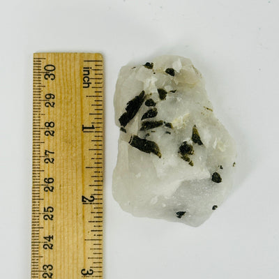 epidote on matrix next to a ruler for size reference