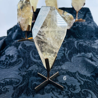 natural citrine on metal stand with decorations in the background