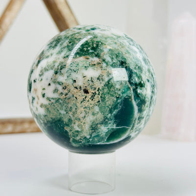 moss agate sphere with decorations in the background