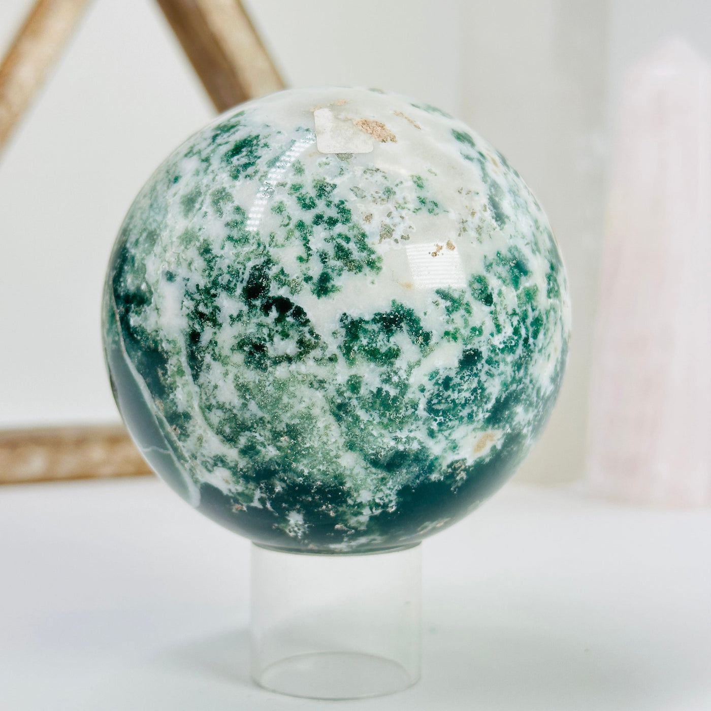 moss agate sphere with decorations in the background 