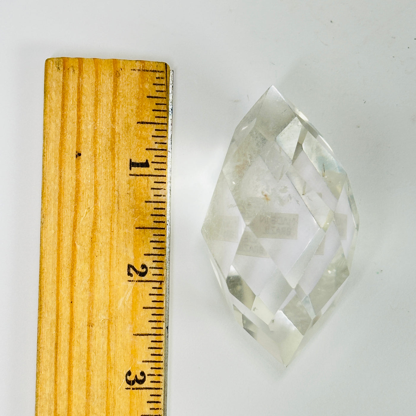 crystal quartz point next to a ruler for size reference