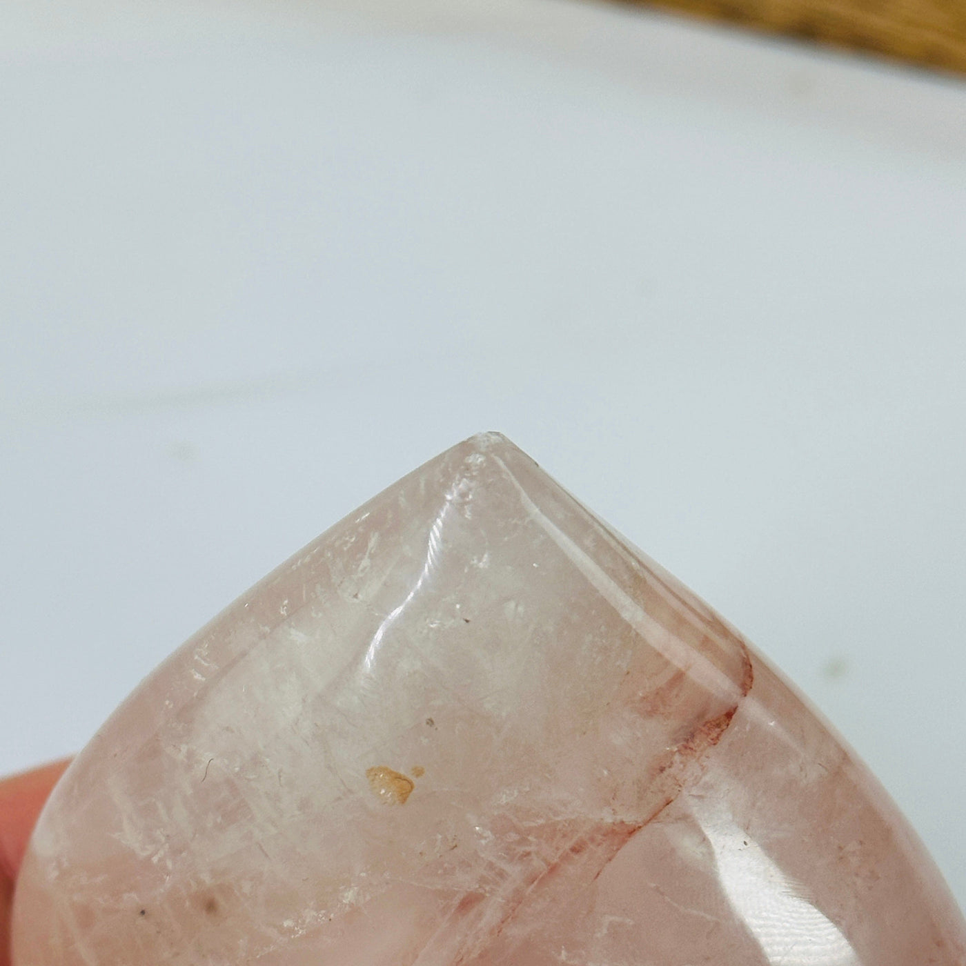 ROSE QUARTZ HEART WITH DECORATIONS IN THE BACKGROUND