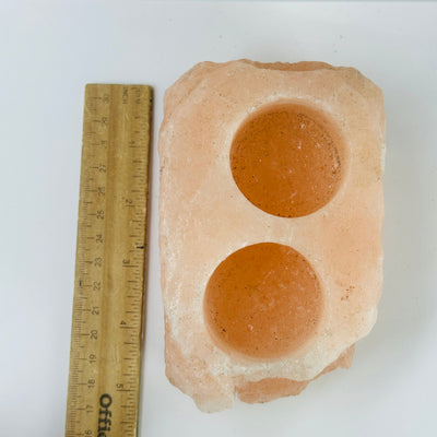 Himalayan salt candle holder next to a ruler for size reference