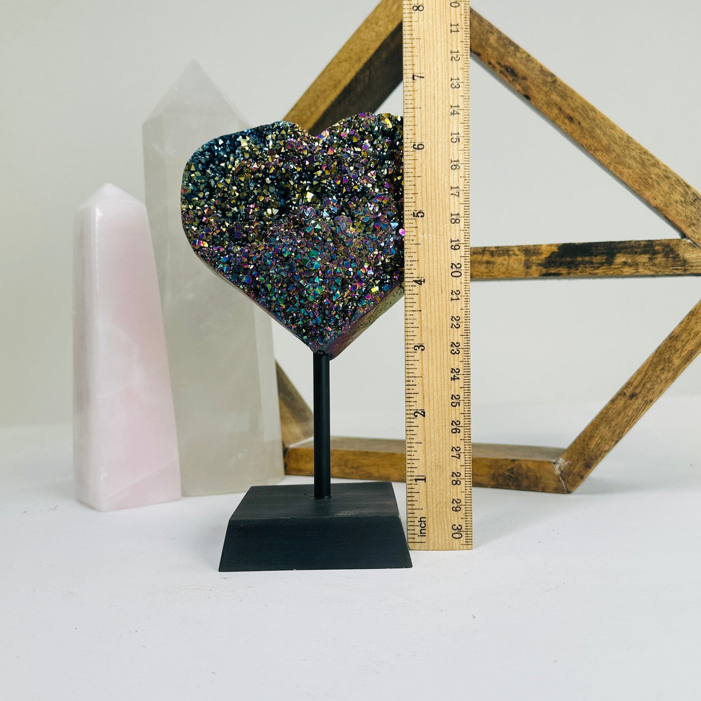 titanium coated heart on stand with decorations in the background