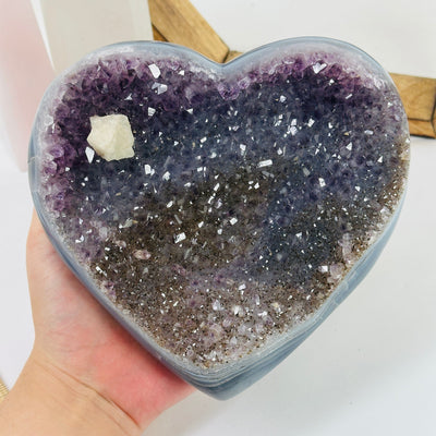 amethyst heart with decorations in the background