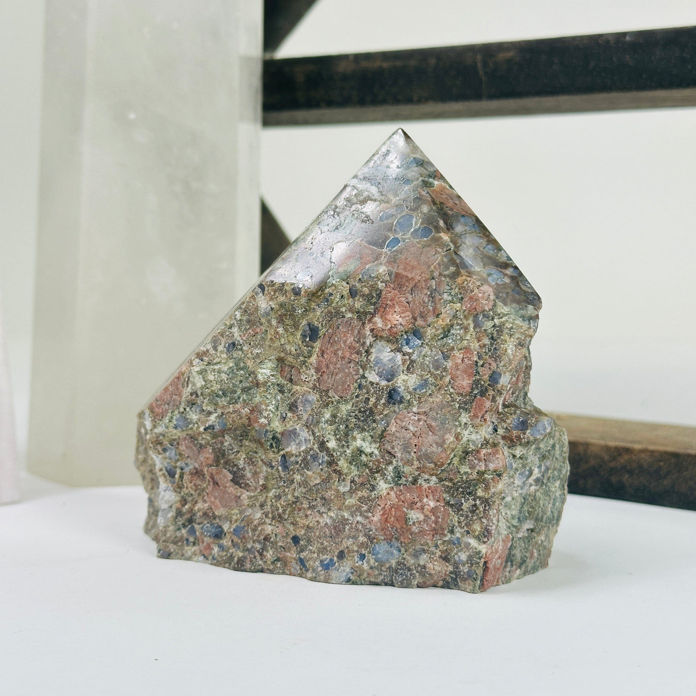 rhyolite semi polished point with decorations in the background