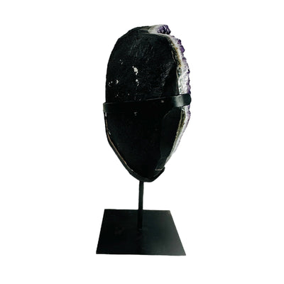 side view of amethyst on metal stand on white background