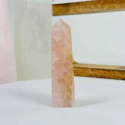 rose quartz obelisk with decorations in the background