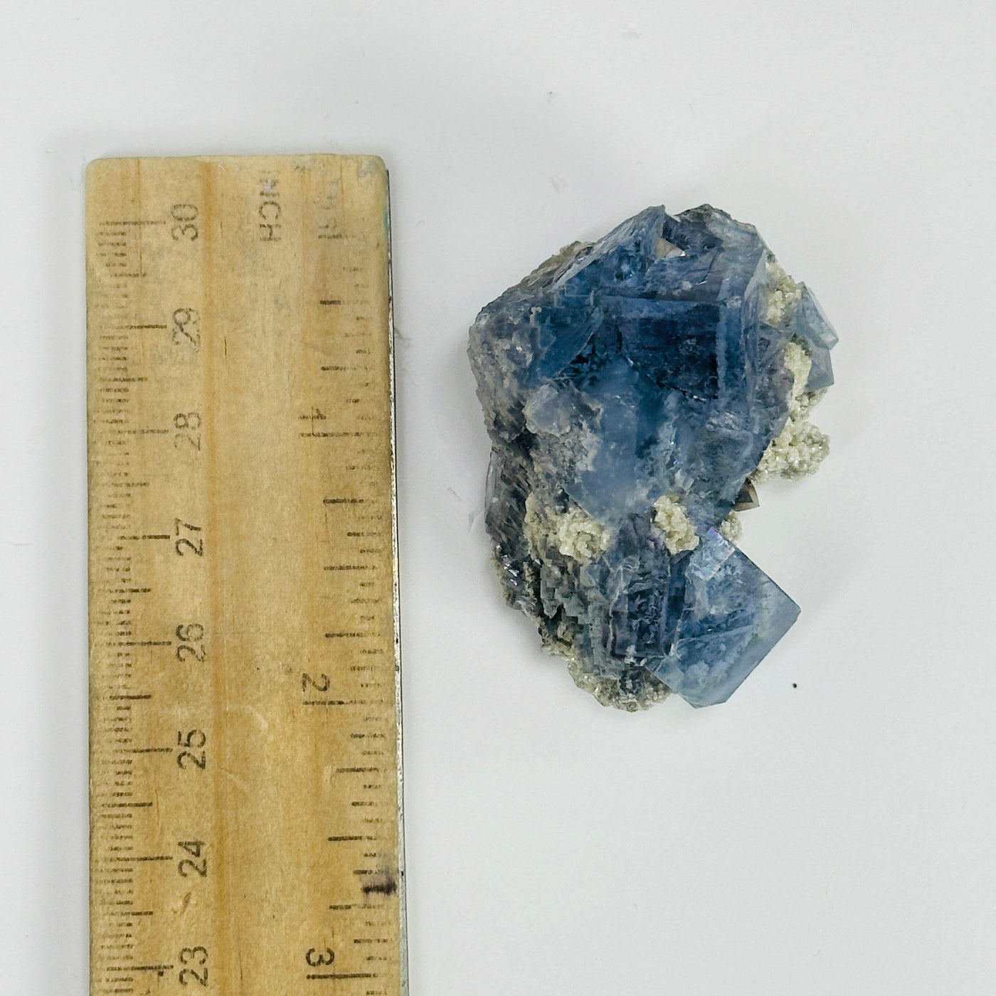 blue fluorite next to a ruler for size reference