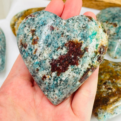 amazonite heart with decorations in the background