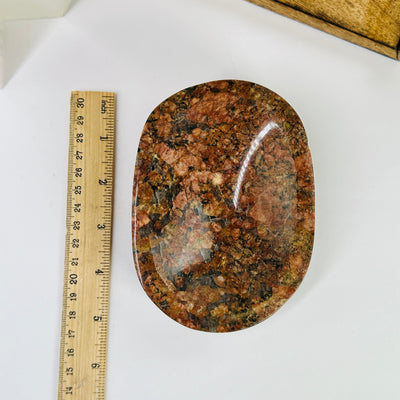 feldspar and tourmaline bowl next to a ruler for size reference