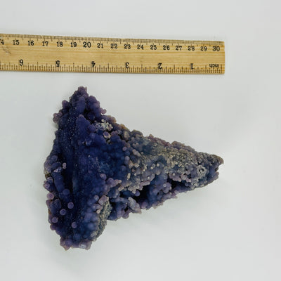 grape agate cluster next to  a ruler for size reference