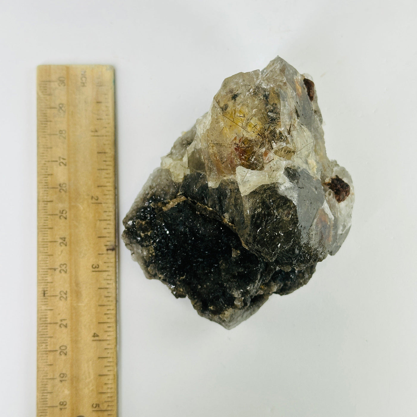 rutile quartz next to a ruler for size reference