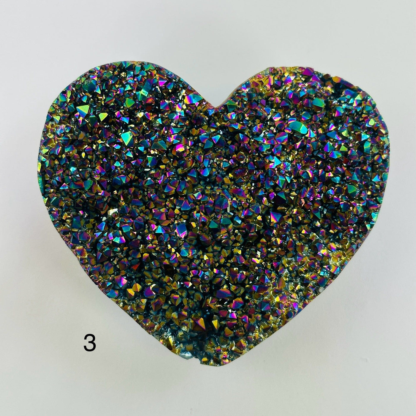 Rainbow titanium heart with decorations in the background
