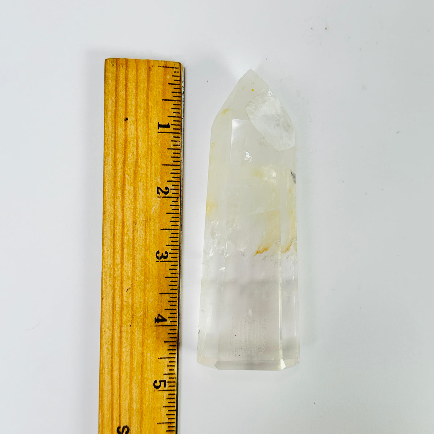 crystal quartz point next to a ruler for size reference