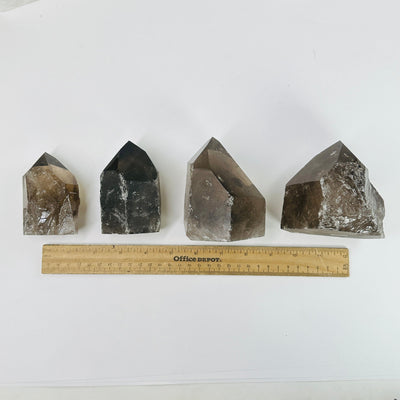 smoky quartz semi polished points next to a ruler for size reference