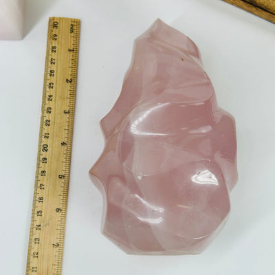 rose quartz flame point next to a ruler for size reference