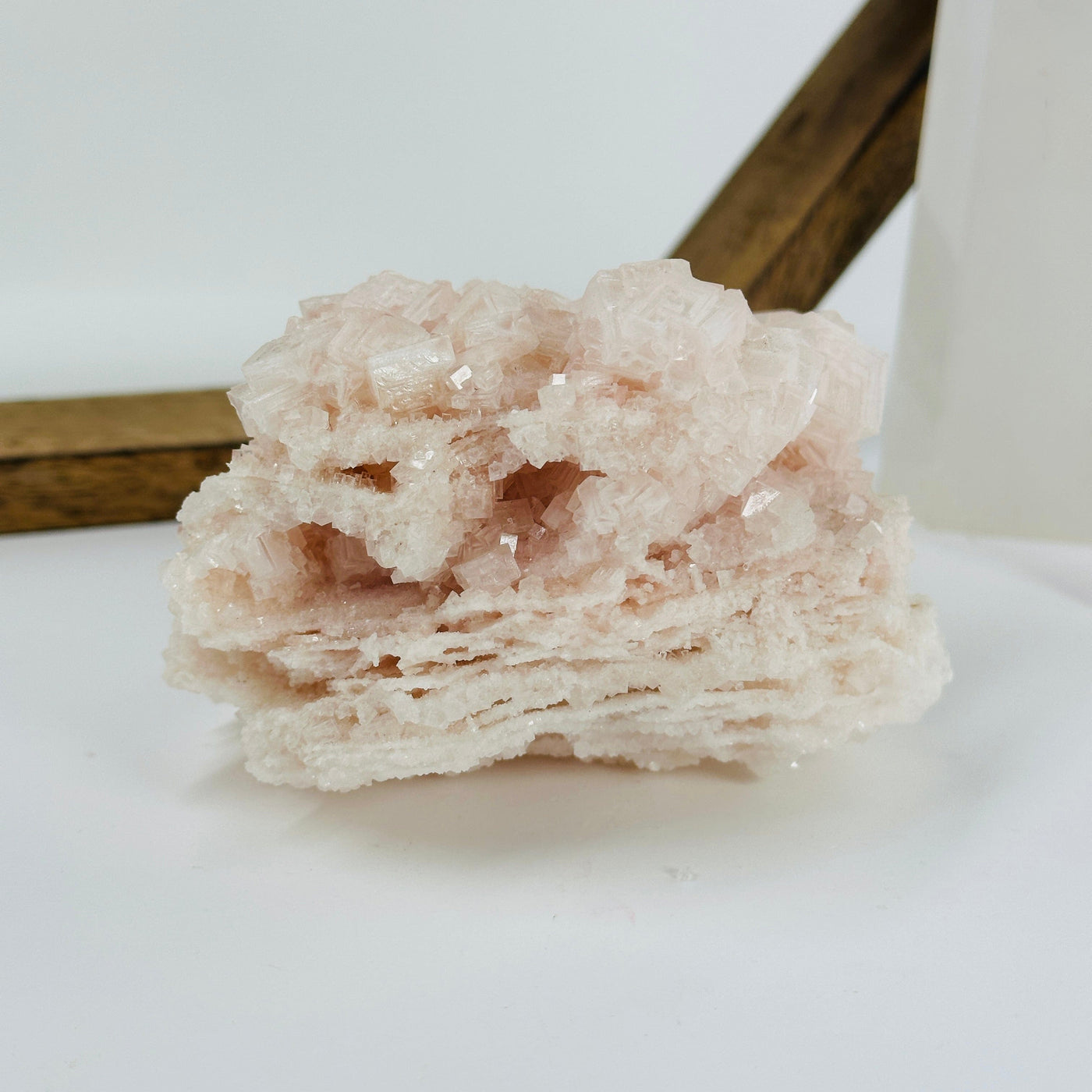 pink halite cluster with decorations in the background