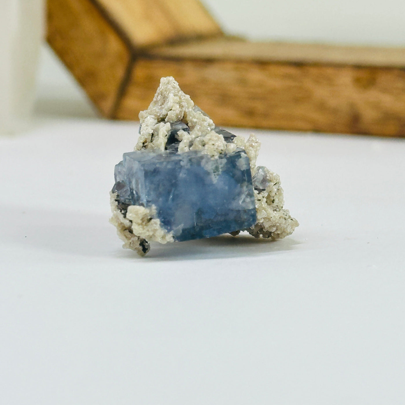 Blue fluorite crystal with decorations in the background