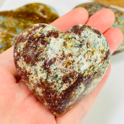 amazonite heart with decorations in the background