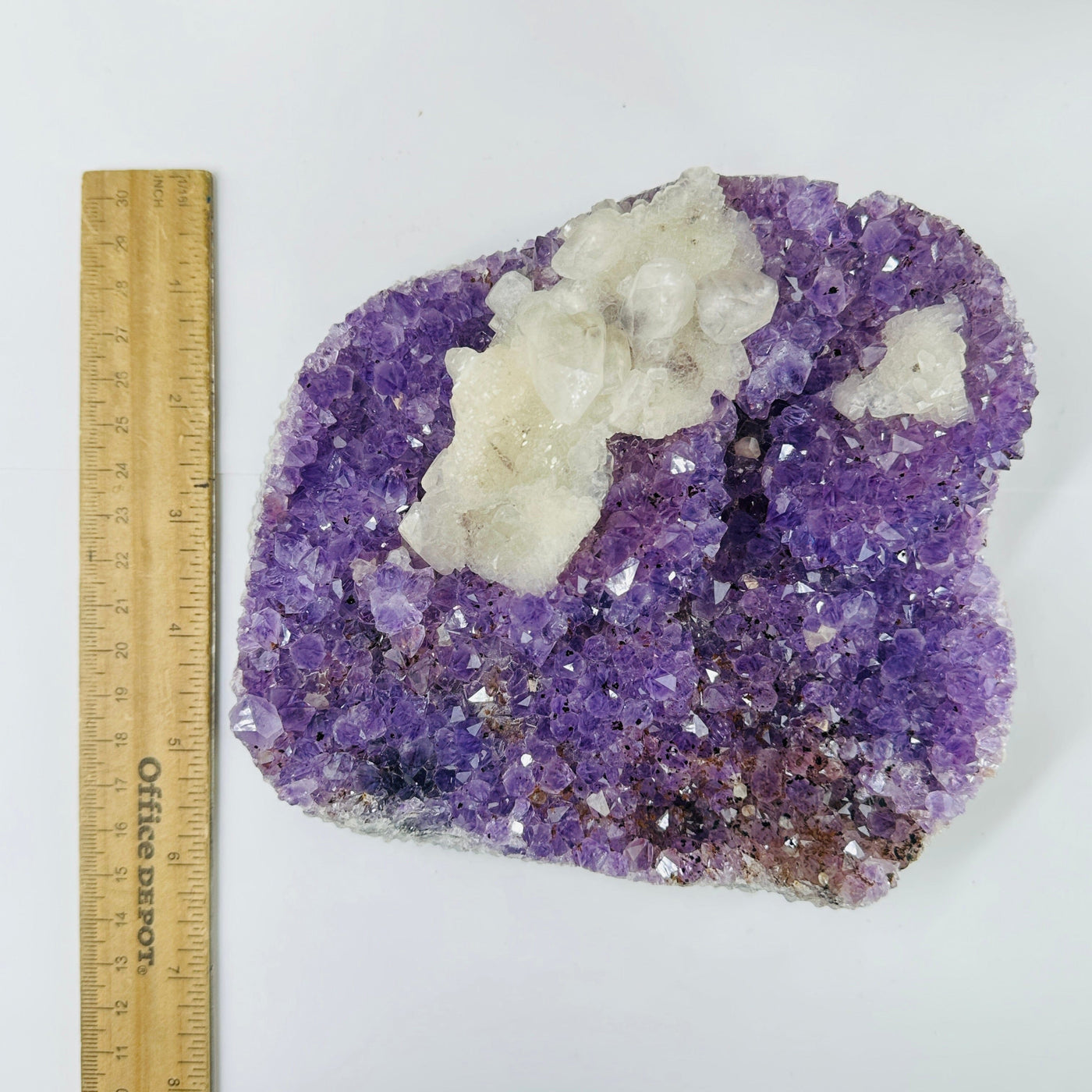 amethyst cluster next to a ruler for size reference