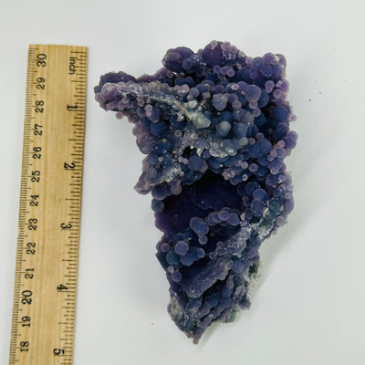Grape agate next to a ruler 