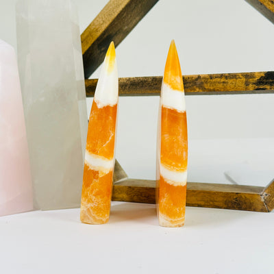 BANDED CALCITE POint with decorations in the background