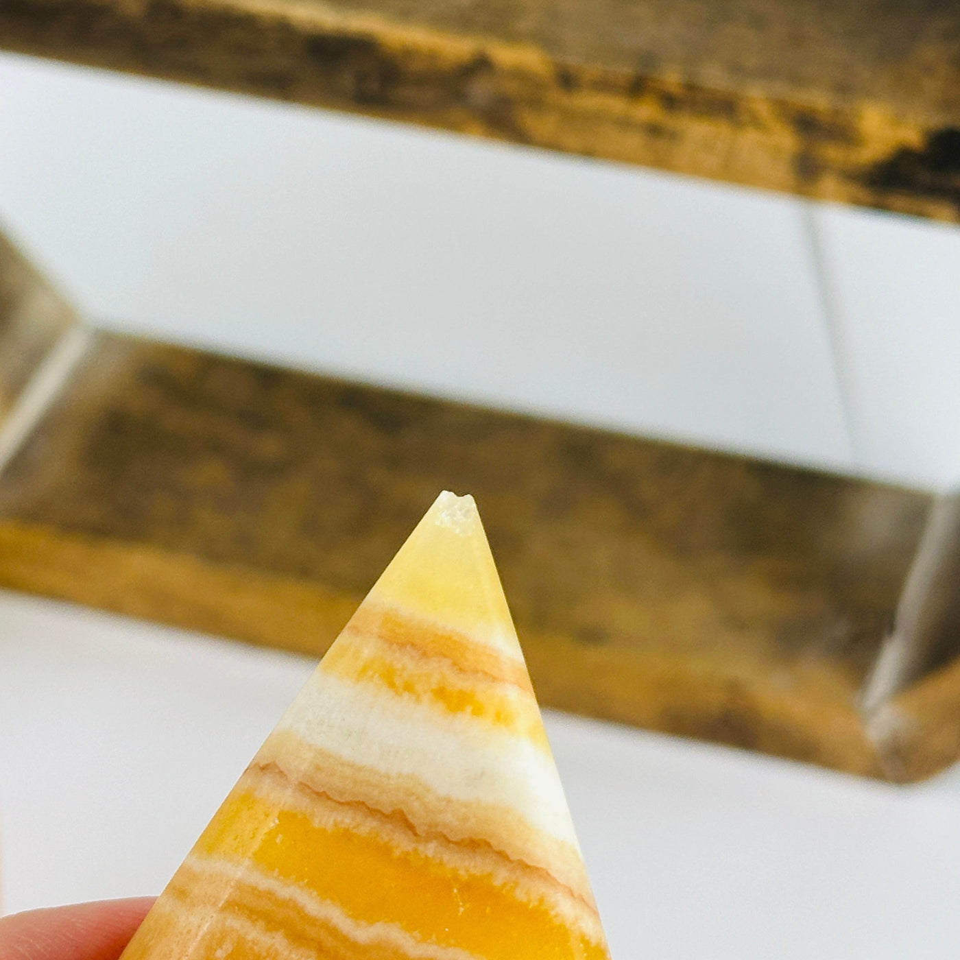 calcite point with decorations in the background