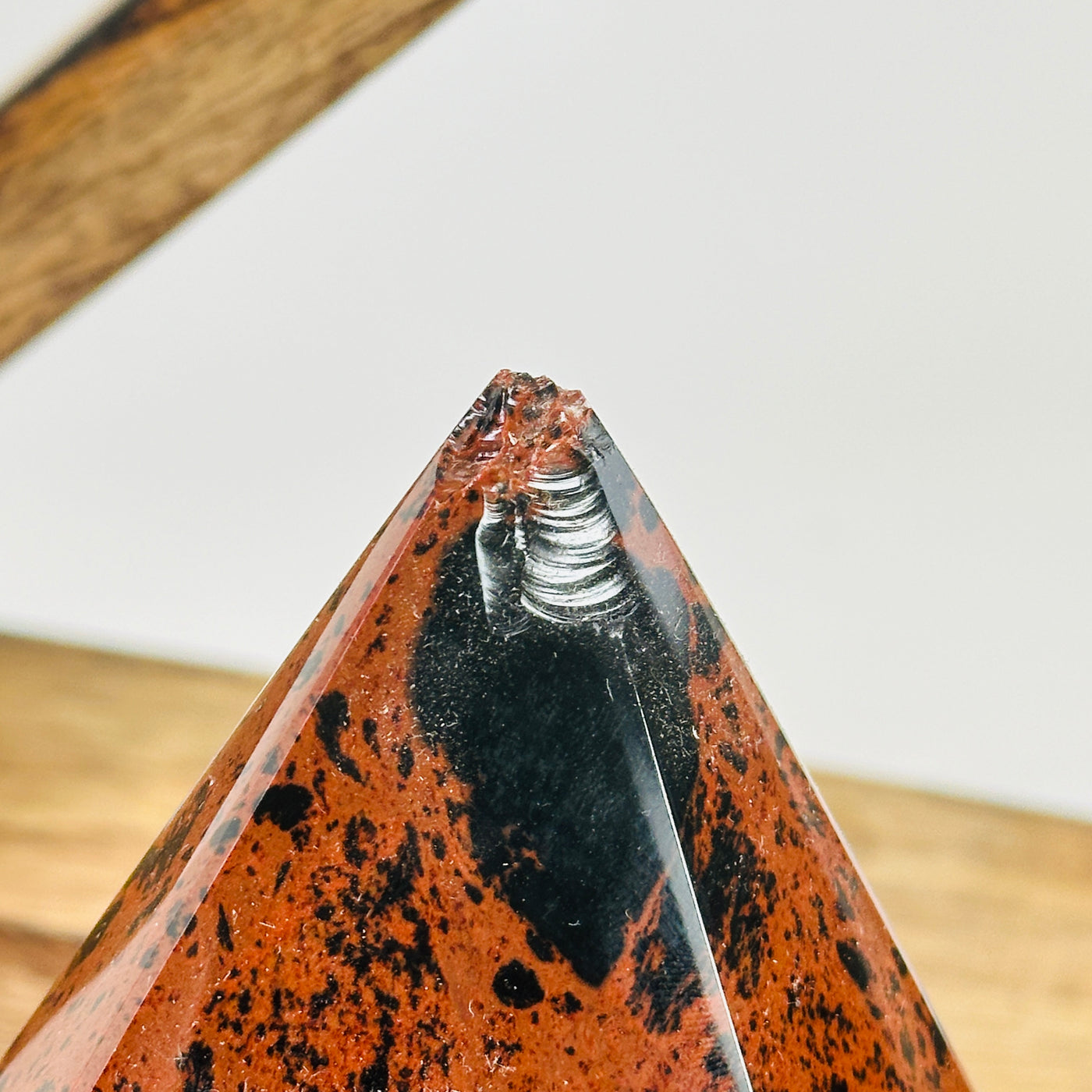 mahogany obsidian point with decorations in the background