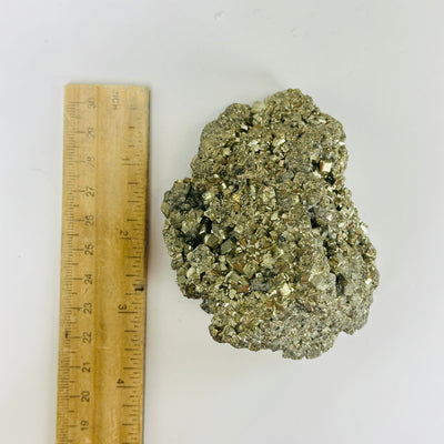 pyrite next to a ruler for size reference