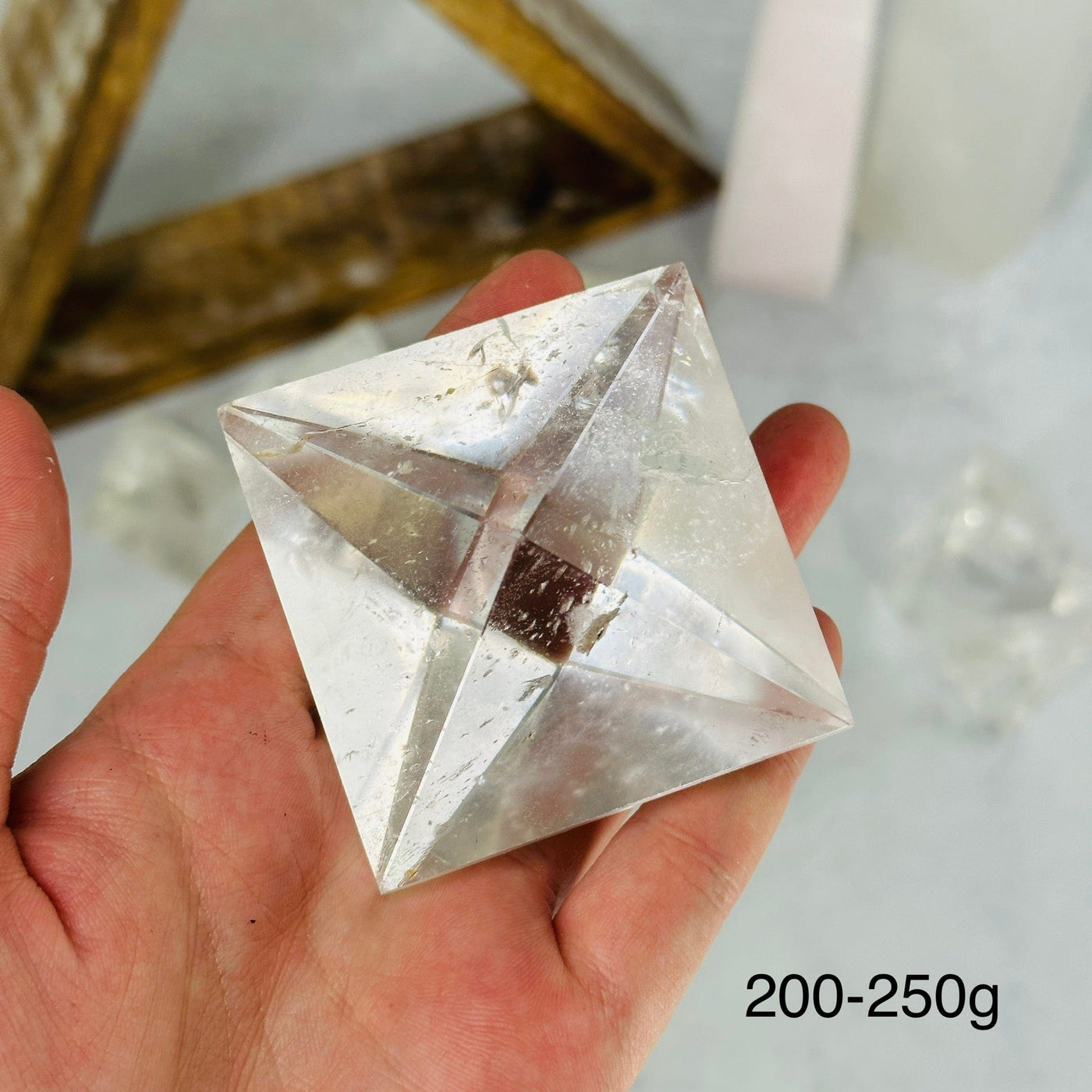 hand holding up 200-250g crystal quartz shape