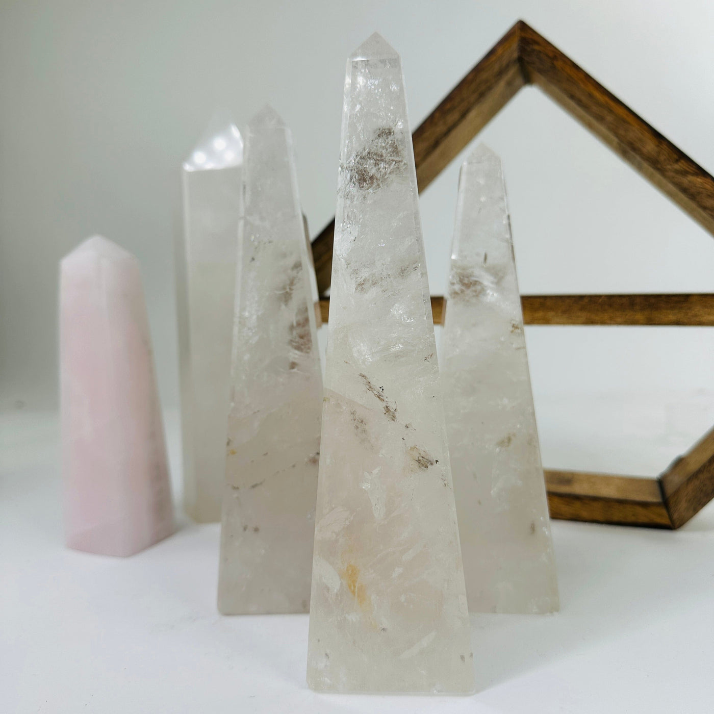 CRYSTAL QUARTZ OBELISK WITH DECORATIONS IN THE BACKGROUND