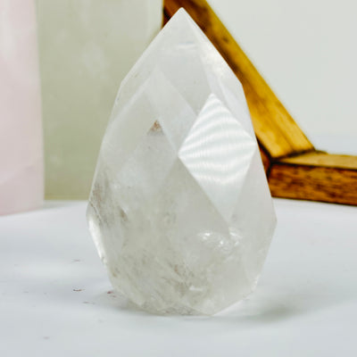 crystal quartz point with decorations in the background