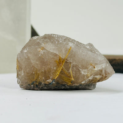 rutilated smokey quartz with decorations in the background