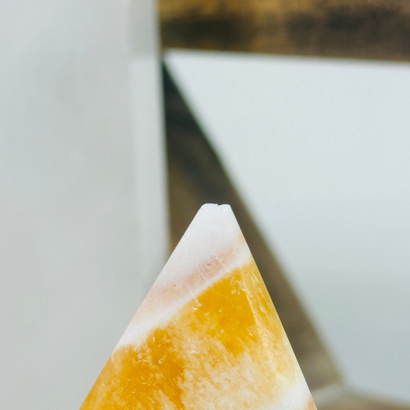 calcite point with decorations in the background