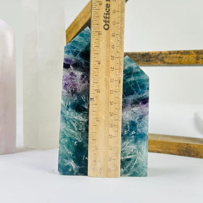 fluorite point next to a ruler for size reference