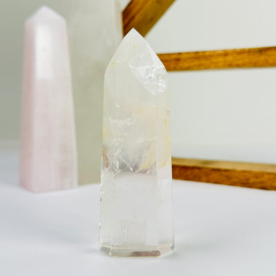 crystal quartz point with decorations in the background