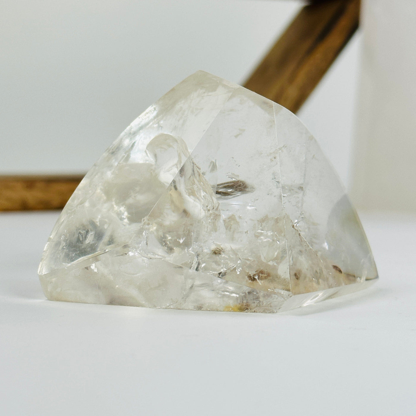 polished crystal quartz with inclusions with decorations in the background